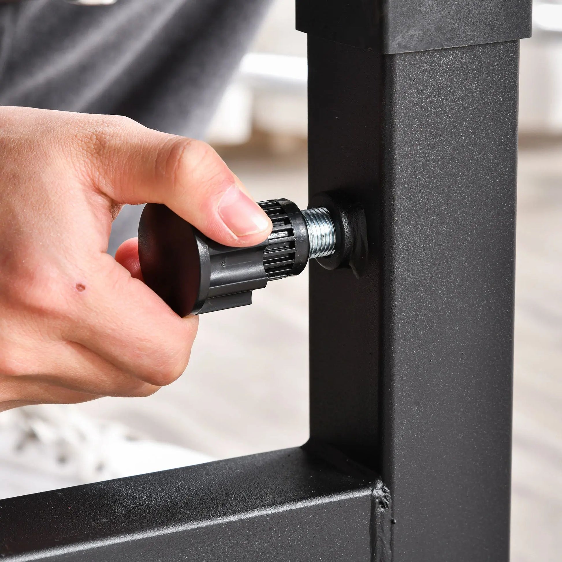 A hand turns the black adjustment knob on the JB Muscle HOMCOM Multi-Exercise Full-Body Weight Rack with Bench Press, Leg Extension, Chest Fly Resistance Band & Preacher Curl.