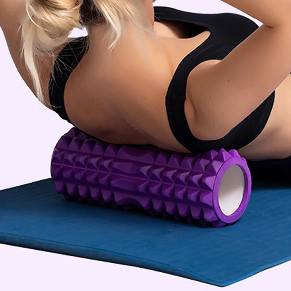 A woman is laying on a yoga mat with a JB Muscle™ Ultimate Foam Roller for Deep Tissue Massage, which provides essential support during workout and helps improve muscle flexibility and recovery.
