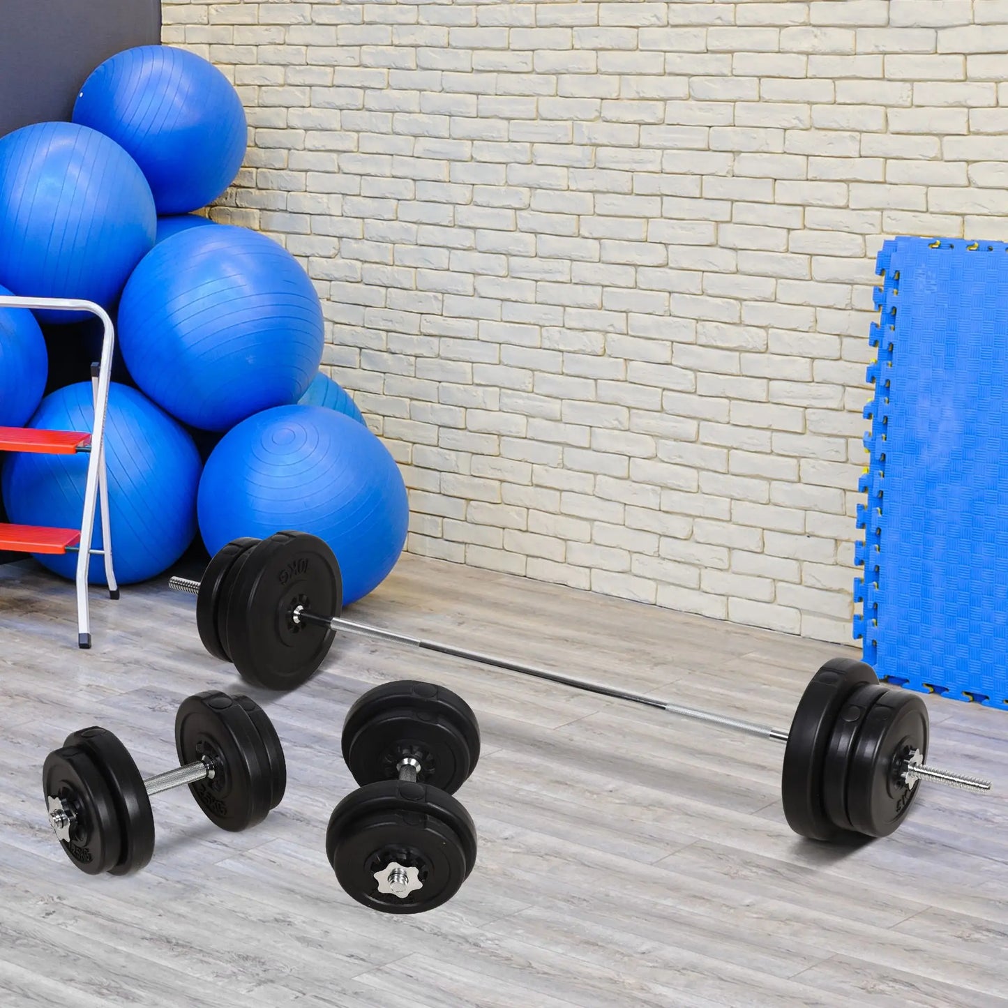 A JB Muscle Adjustable Dumbbell and Barbell Set 65kg for home gym workouts sits on a wooden floor next to blue exercise balls and a foam mat, set against a white brick wall.