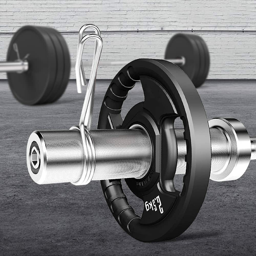Close-up of the JB Muscle Olympic Barbell Bar with 2 inch Spring Clips, set on a gym floor, with another barbell in the background against a brick wall. Available in 4FT, 5FT, 6FT, and 7FT lengths for weight lifting.