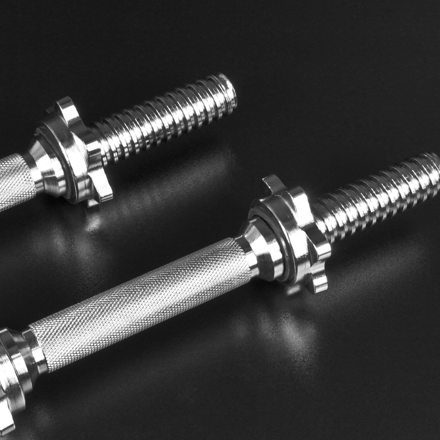 Two JB Muscle Spinlock DUMBBELL BARS for 1-inch plates, with threaded ends and star-shaped spinlock collars, are placed on a black surface.